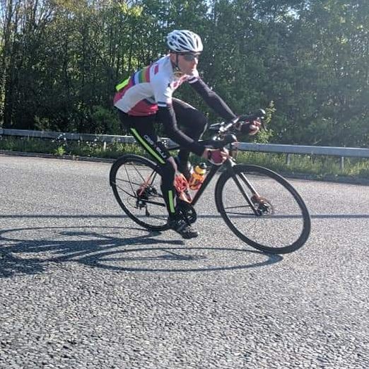 Get comfortable with the basics A cyclist cornering hard on a spring morning wearing tights and long sleeves, their bike has mudguards and you can just see a race number.
