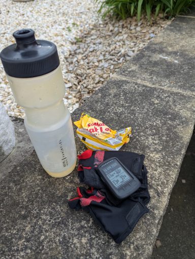 Favourites An empty bottle, malt loaf wrapper and a bike computer on a pair of scruffy track mitts all sat on a wall.